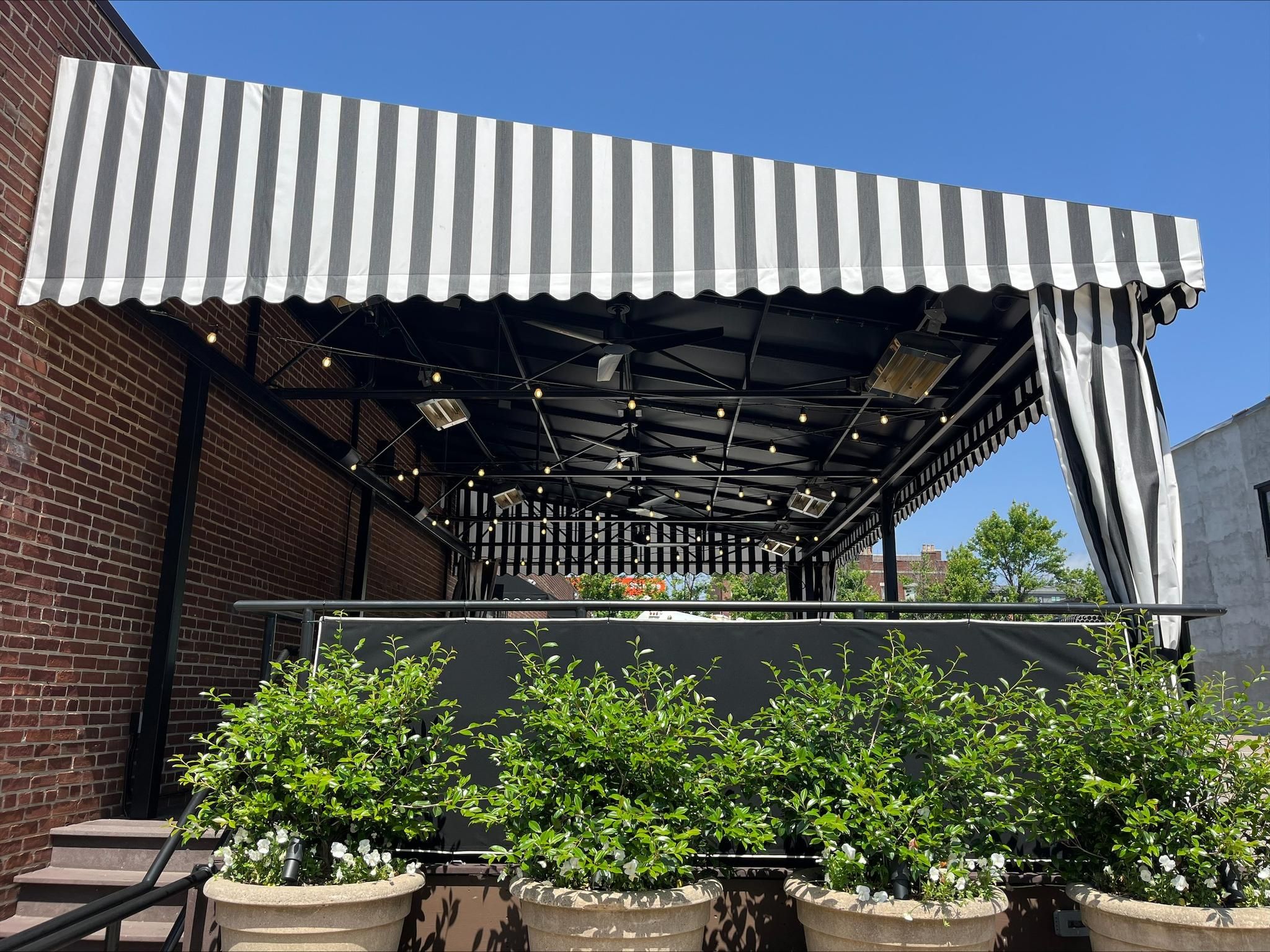 black and white striped awning with tie back curtains