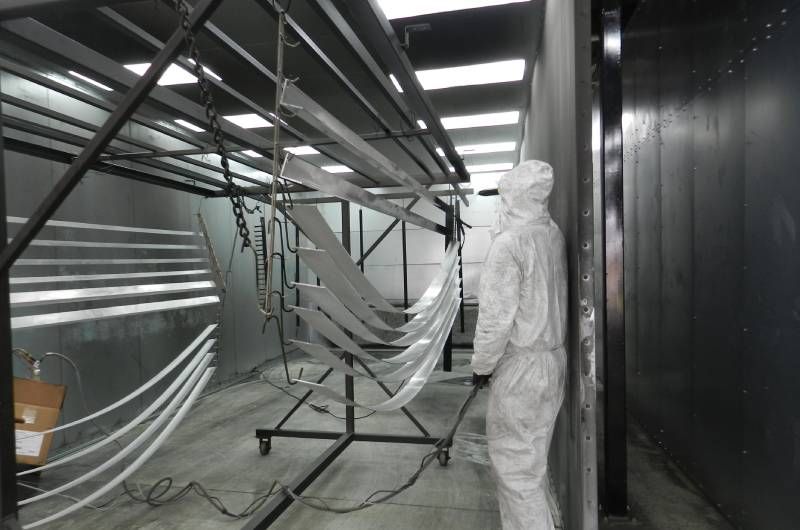 Parasol Awnings employee inspecting a powder coating job