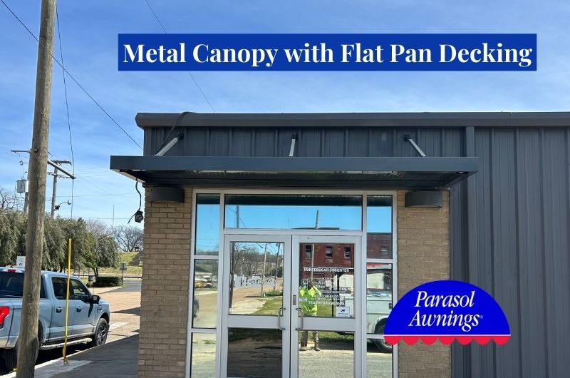 grey suspended metal canopy over glass entry doors