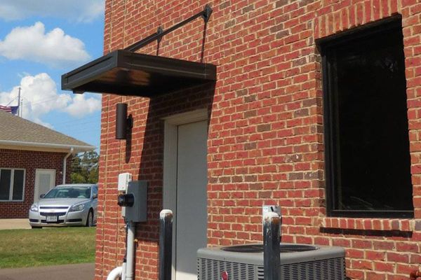 Suspended metal canopy over a door