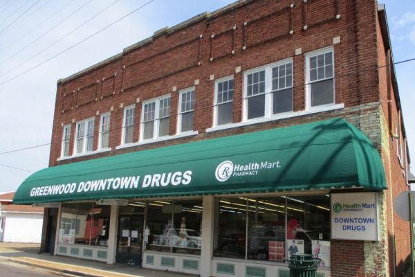 Green convex storefront awning with graphics